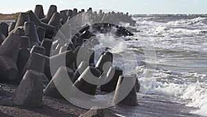 Waves crashing against breakwater consisting of gray concrete tetrapods. Liepaja, Latvia. Liepajas Ziemelu mols